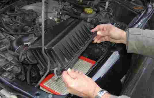 Replacing a vehicle air filter for maintenance.