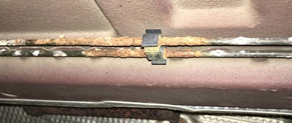 Brake line rust and corrosion under a vehicle.